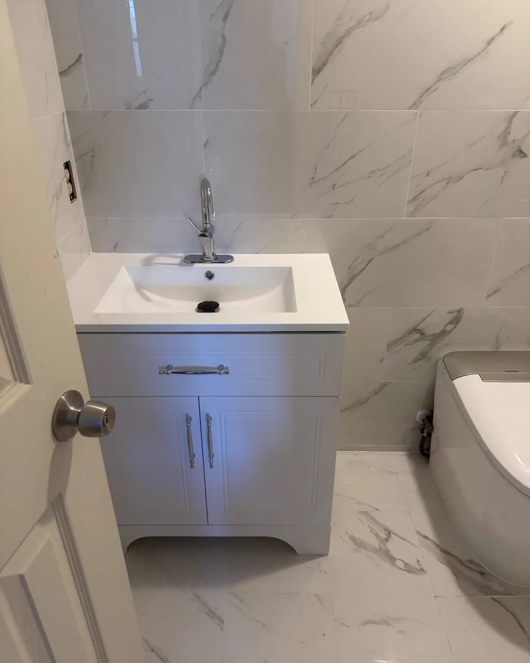 A finished bathroom in Tampa, FL with a new vanity and tiled walls