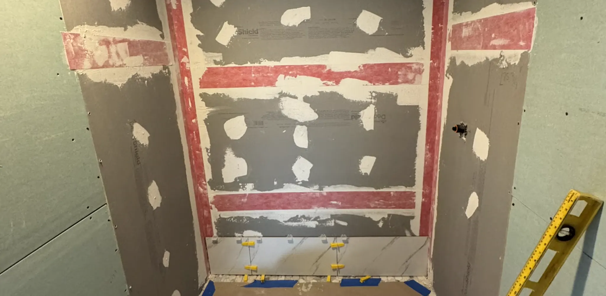 Shower walls in waterproofing membrane with every seam banded before tile