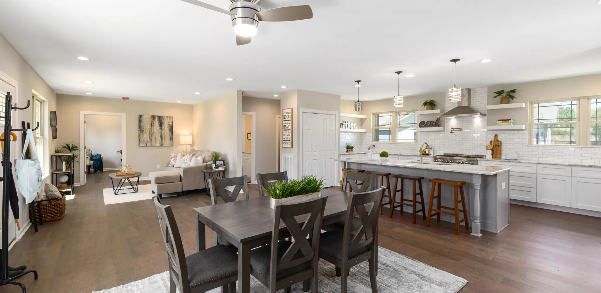 A dining table, kitchen island and living room in one open space, home remodeling