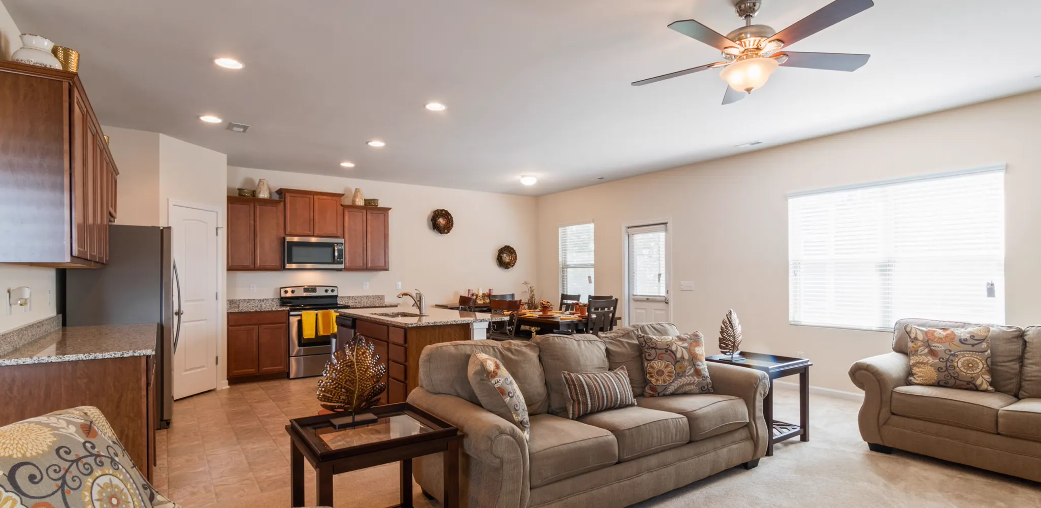 A living room open to a wood cabinet kitchen and dining table, home remodeling