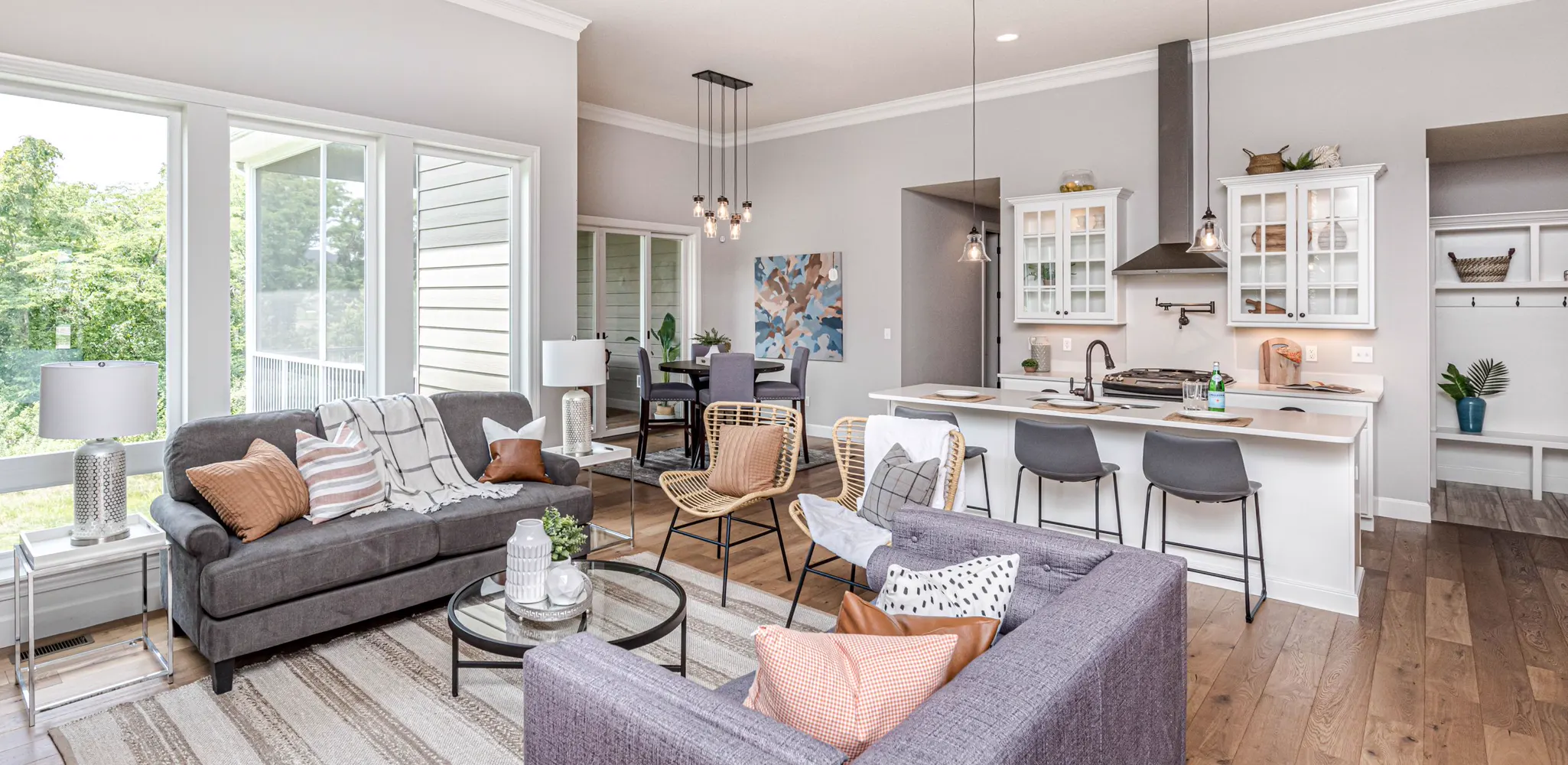Tall windows light a living room, dining area and white kitchen, home remodeling