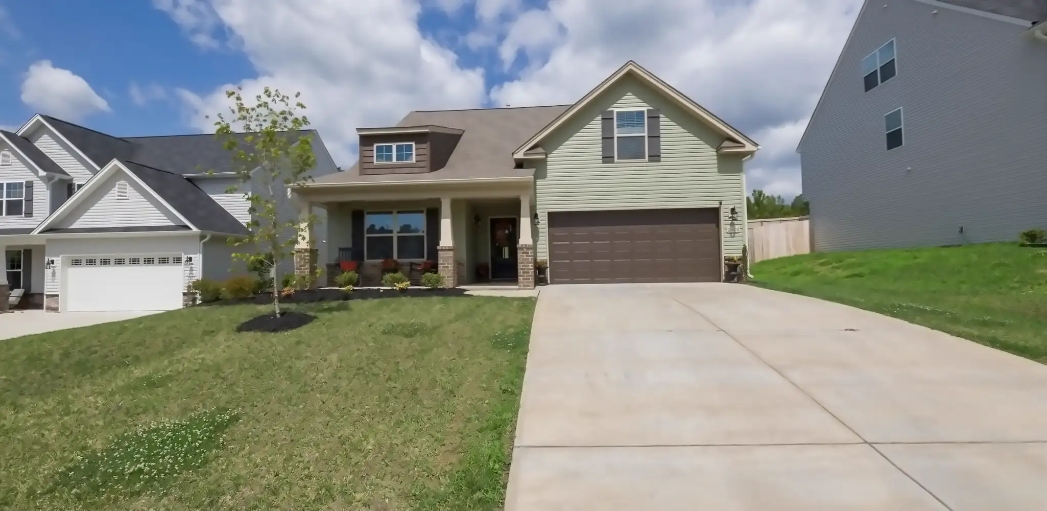 A one story house with a wide concrete driveway, driveways
