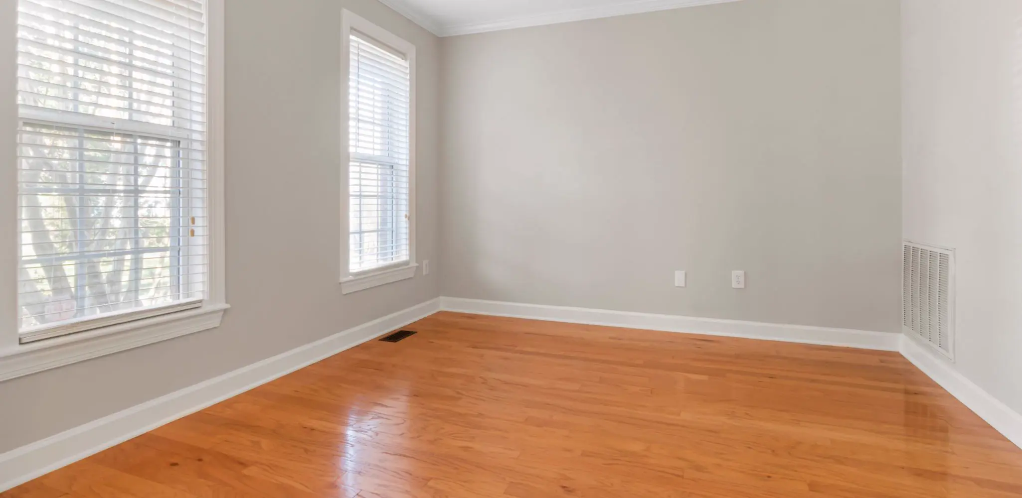 An empty room with new hardwood floors and white walls, flooring installation