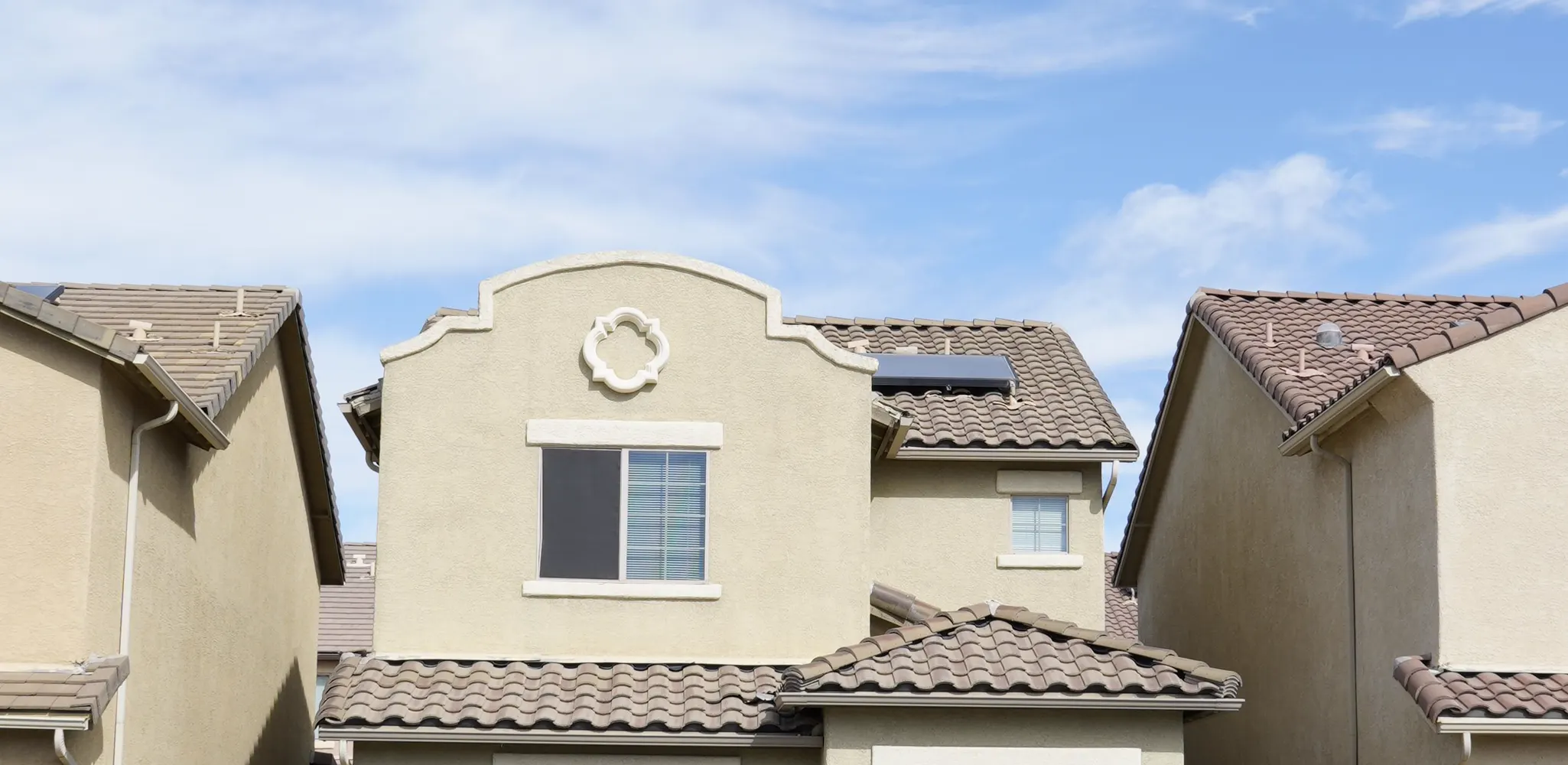A row of painted stucco houses with tile roofs under the Florida sun
