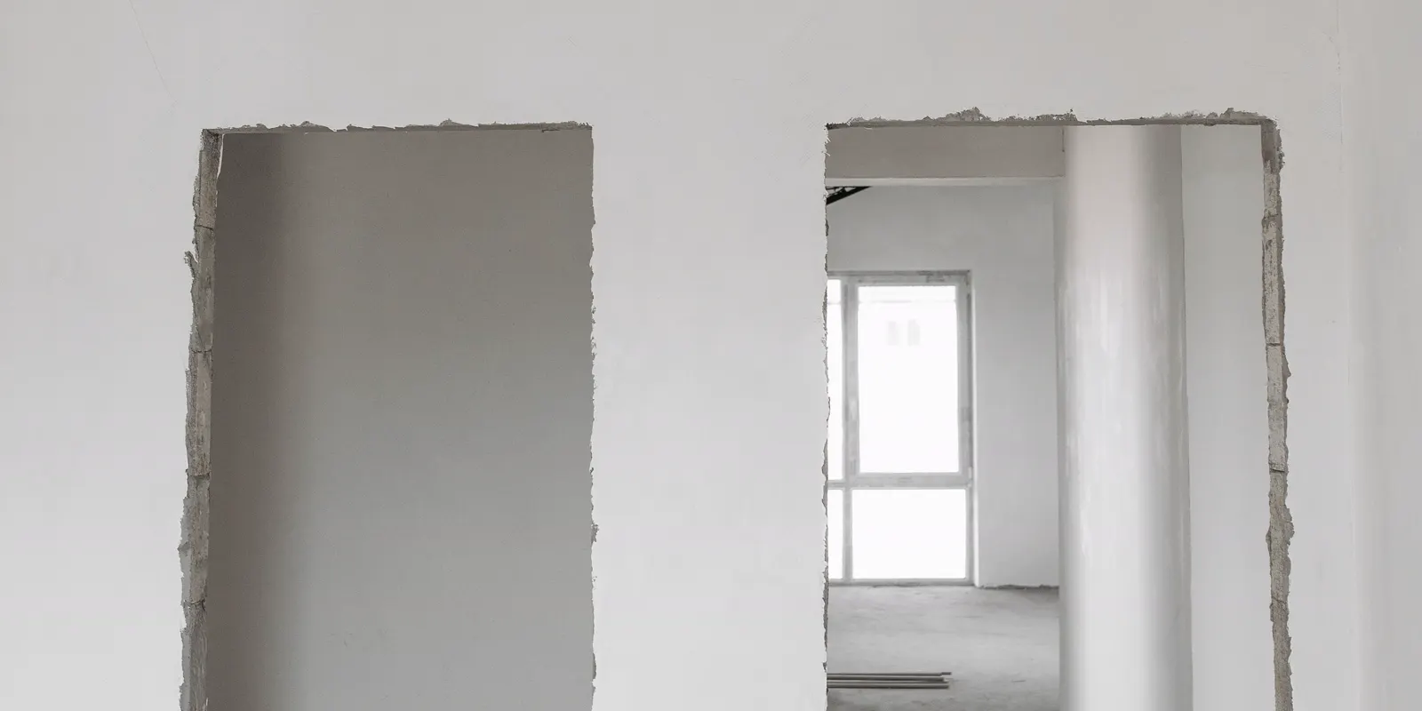 An unfinished room with white plastered walls and a bare floor, flooring cost
