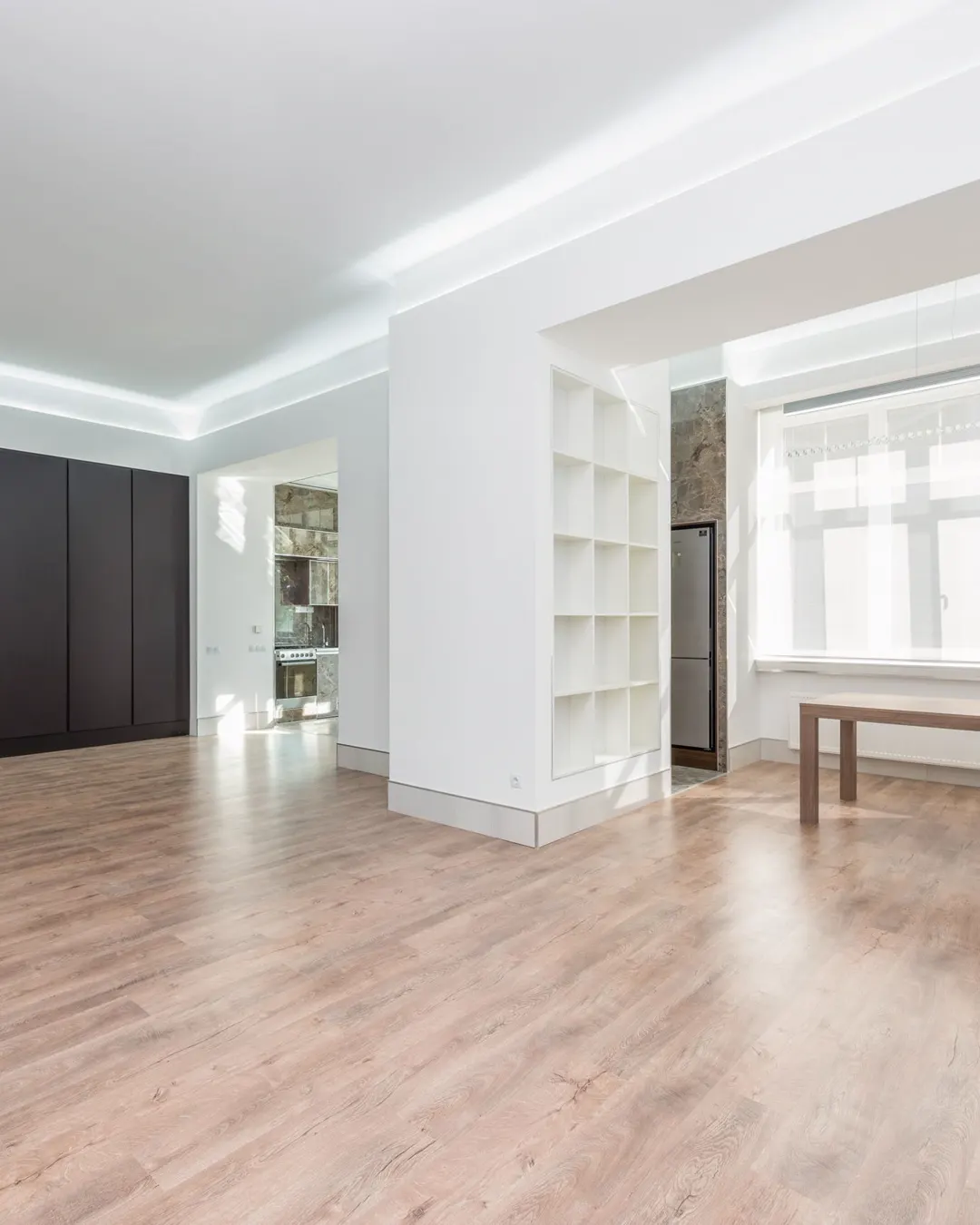 An empty room with a light wood look floor and white walls, flooring cost