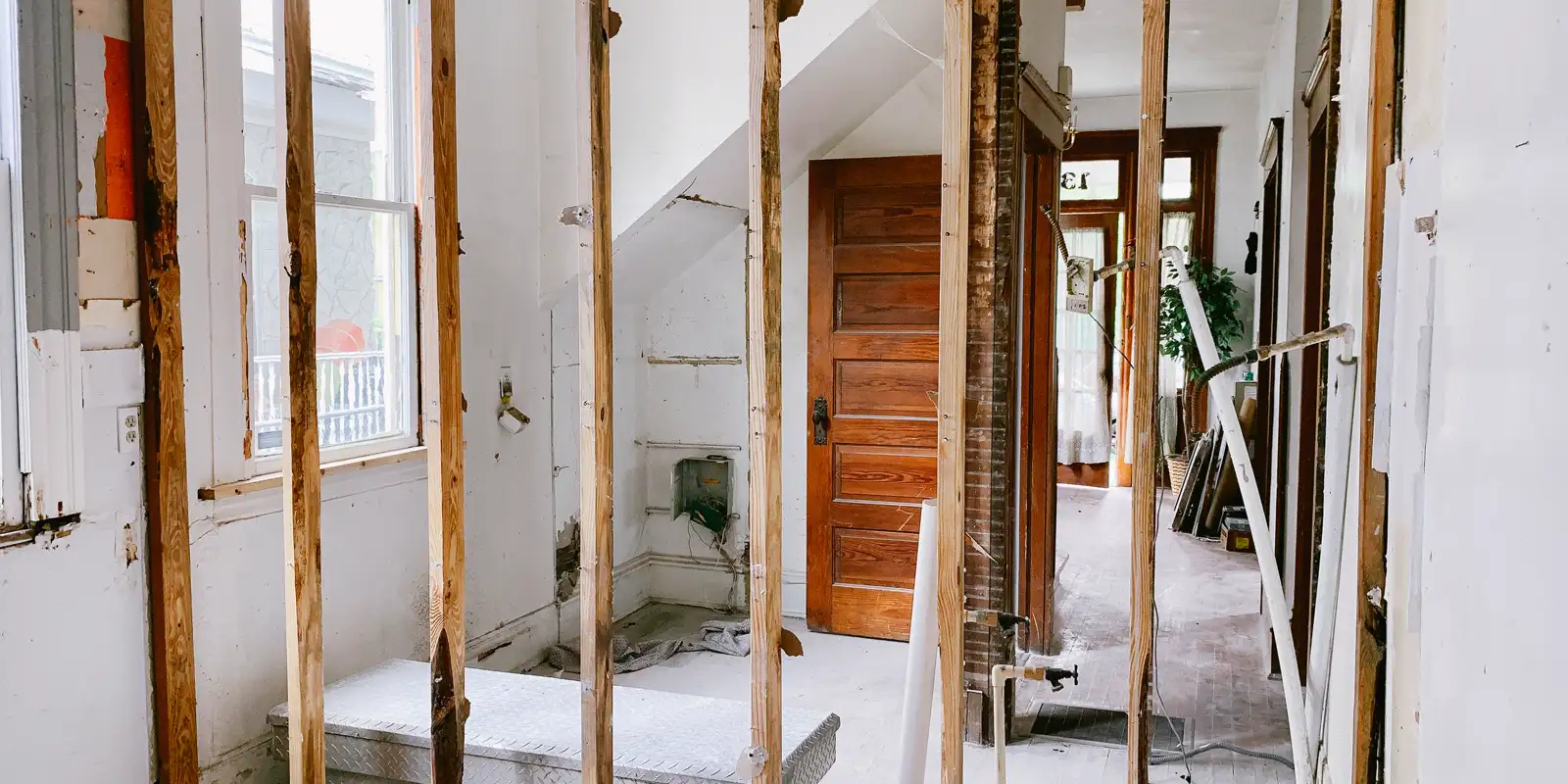 A home under renovation with the wall studs exposed, kitchen cabinet installation
