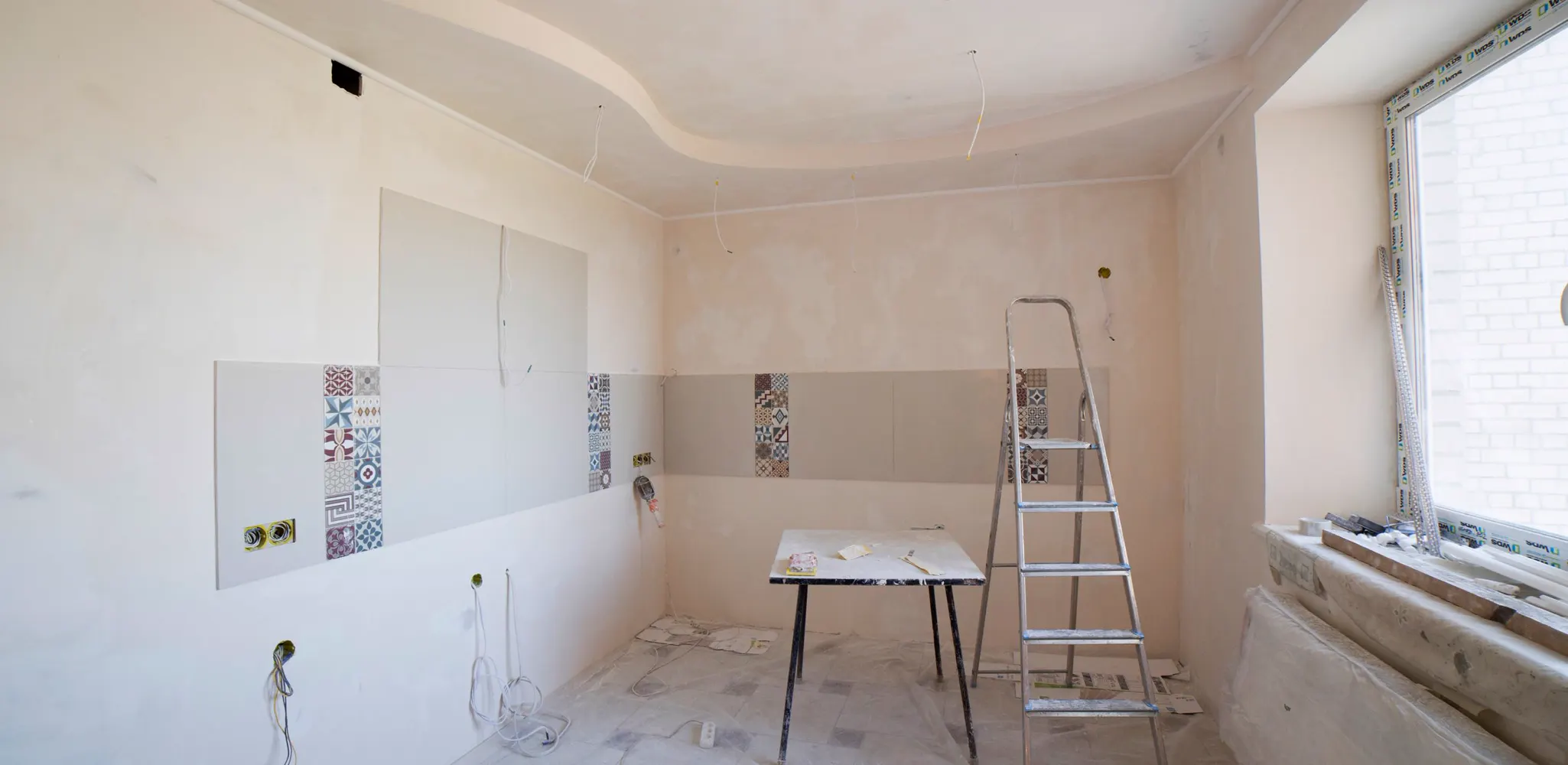 A kitchen mid renovation with a ladder and tools on the floor, kitchen remodel cost