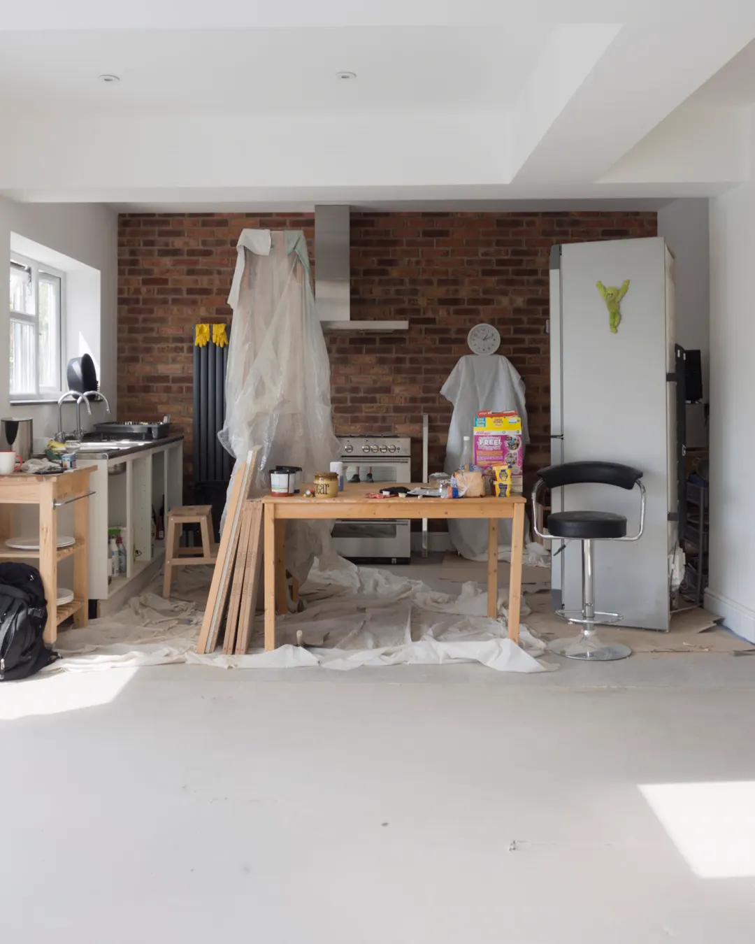 A kitchen under renovation with a ladder and bare walls, kitchen remodel cost