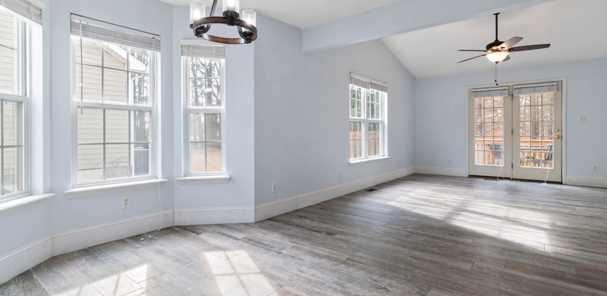 A living room with wide gray brown plank flooring, luxury vinyl plank flooring