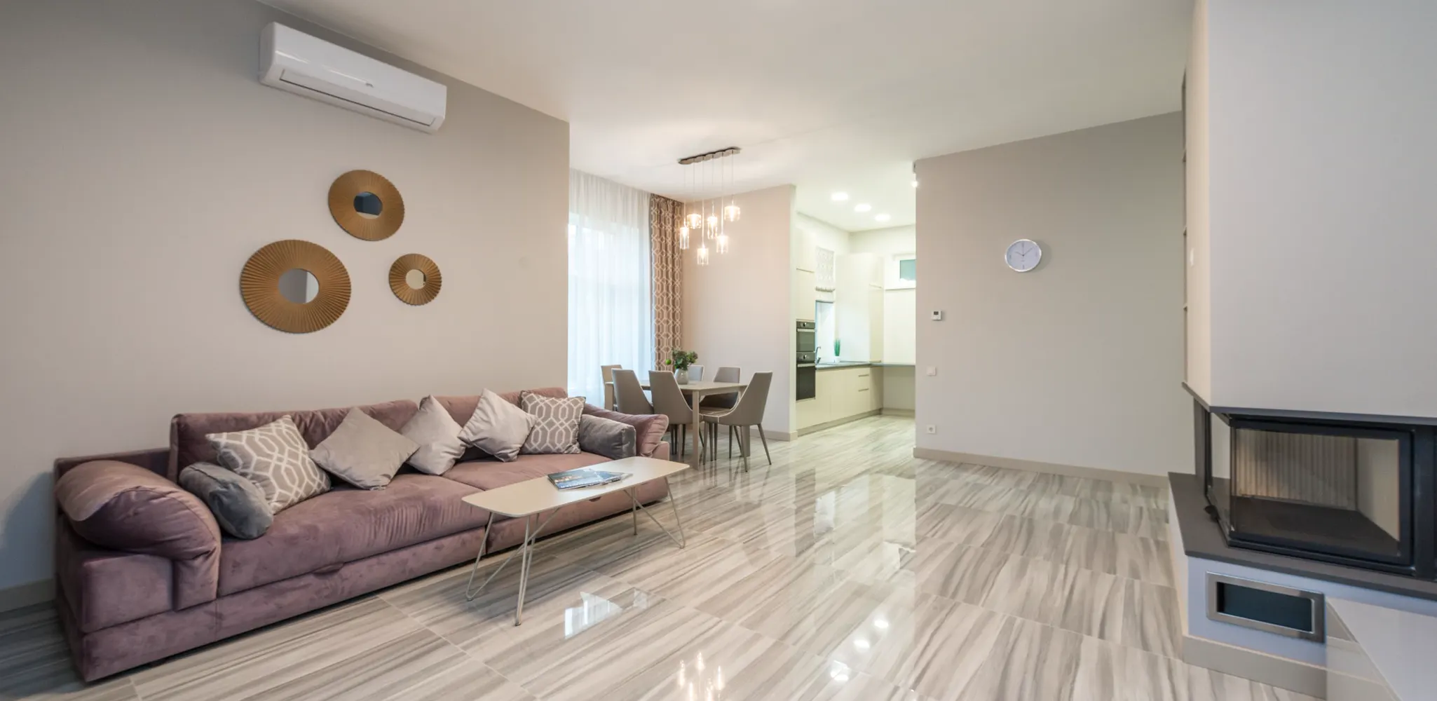 A living room with a glossy white tile floor with soft gray veins, tile flooring installation