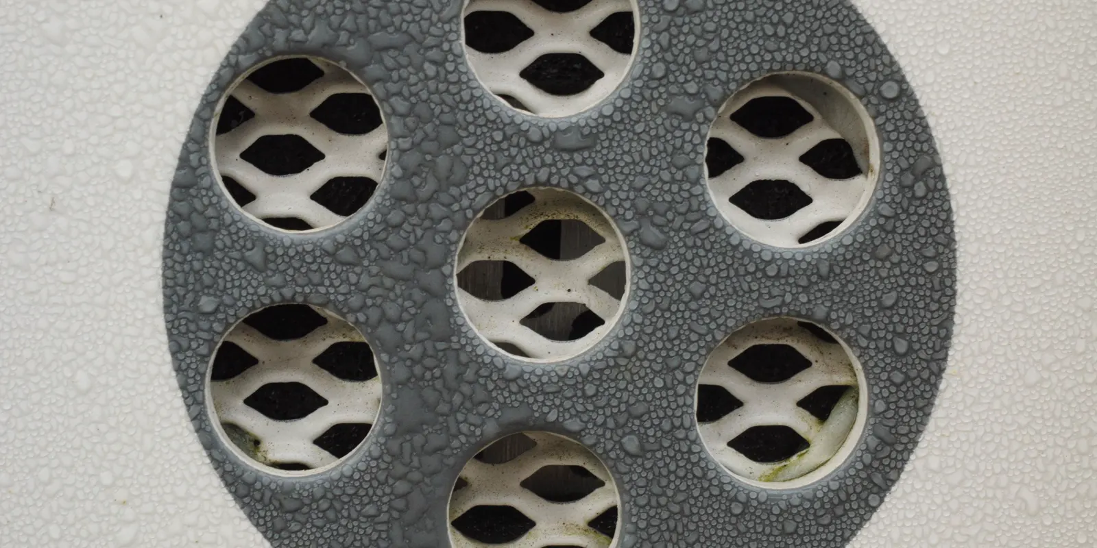 Close up of a round shower drain cover, walk in shower